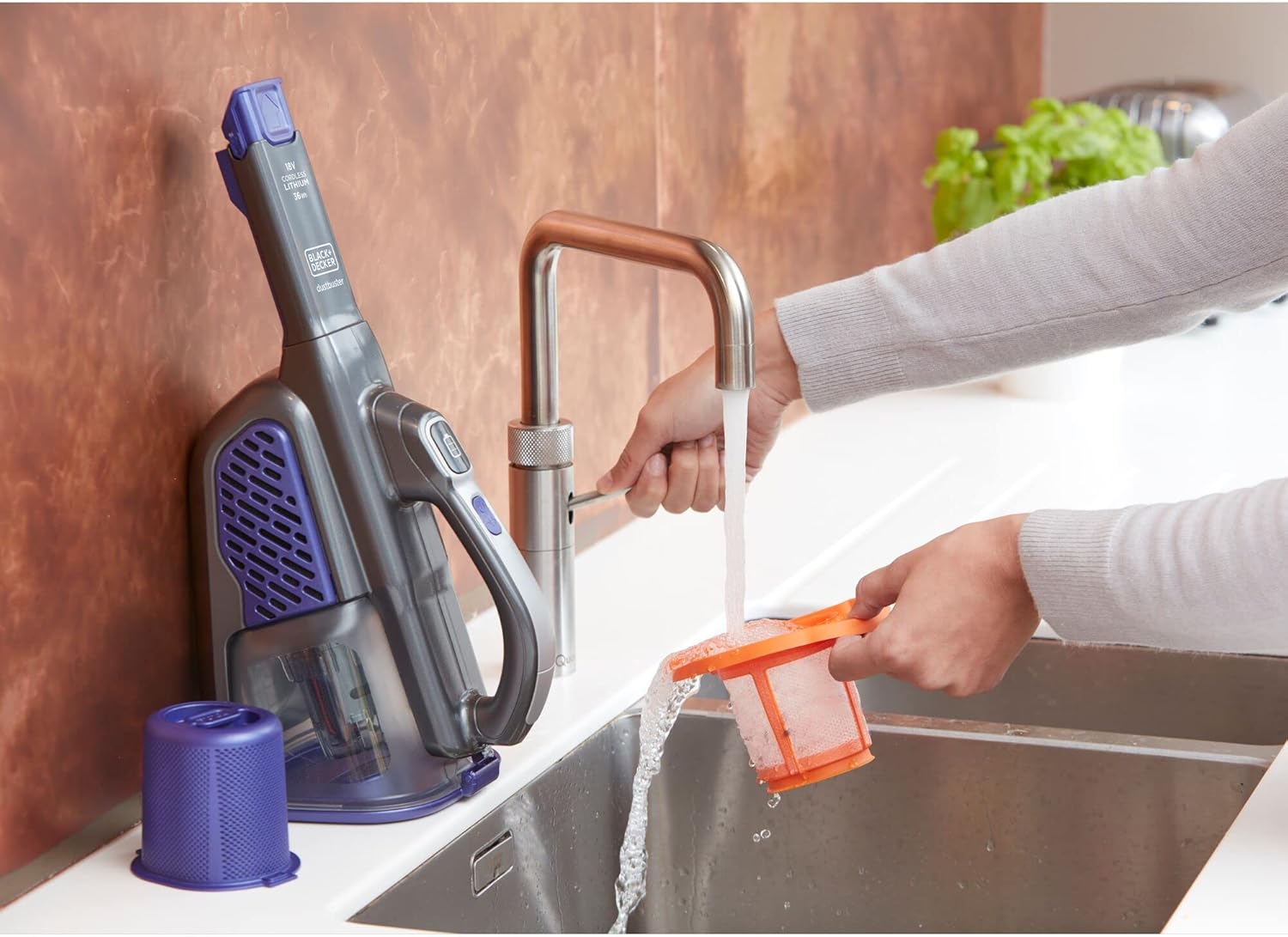Woman washing filter of BLACK+DECKER BHHV520BFP-QW