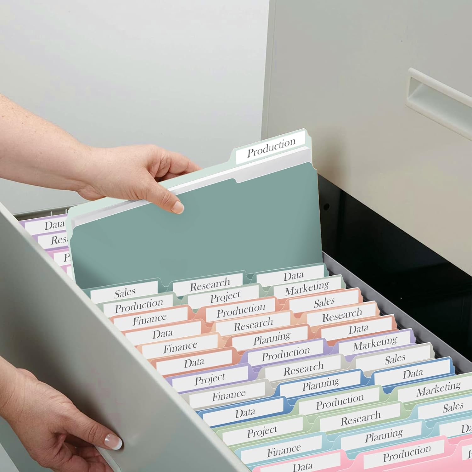 Hands placing a file folder into a file drawer filled with other colored folders