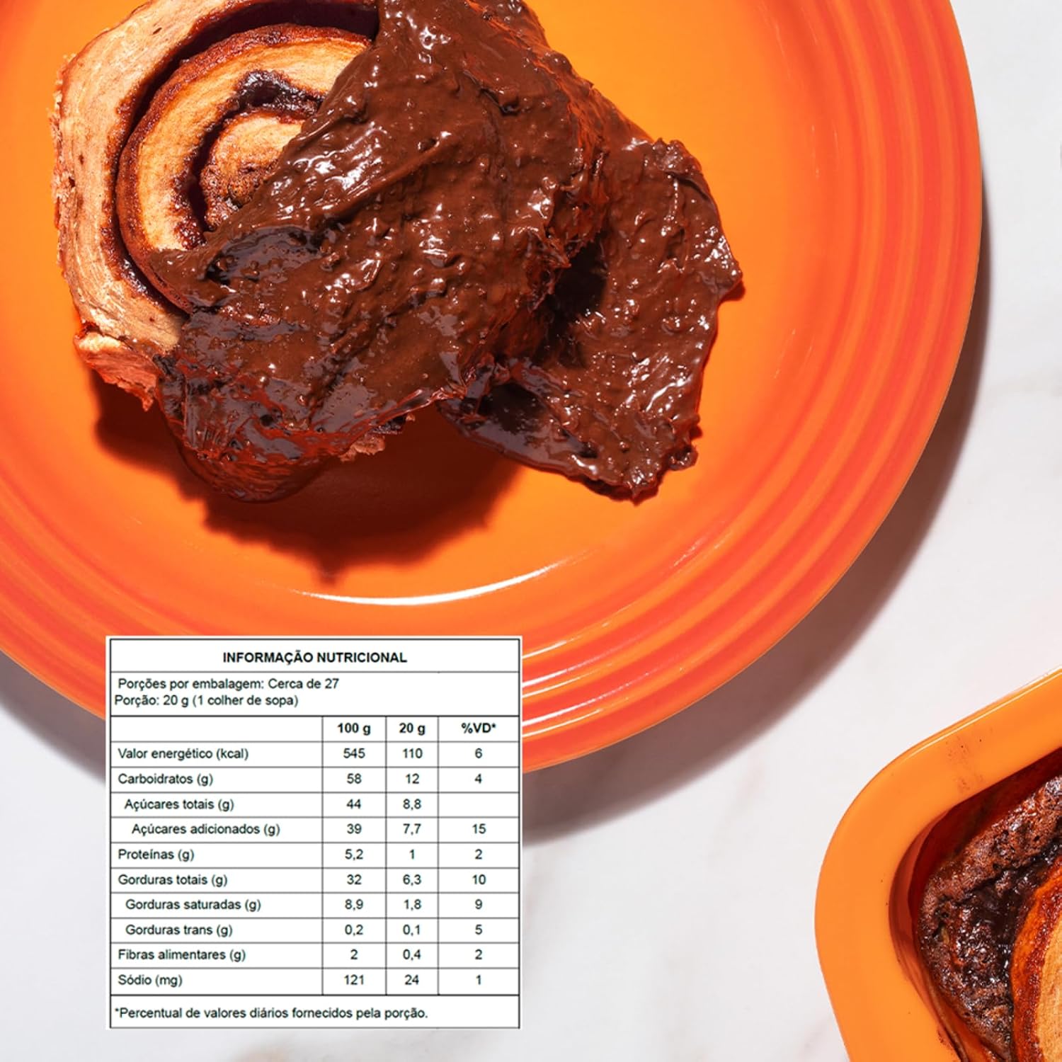 Pão doce enrolado coberto com Creme Crocante Ovomaltine ao lado de tabela nutricional