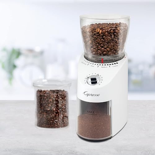 The Capresso Infinity Plus grinder on a kitchen counter beside a jar of coffee beans, showing the 11-ounce hopper and the removable grounds container