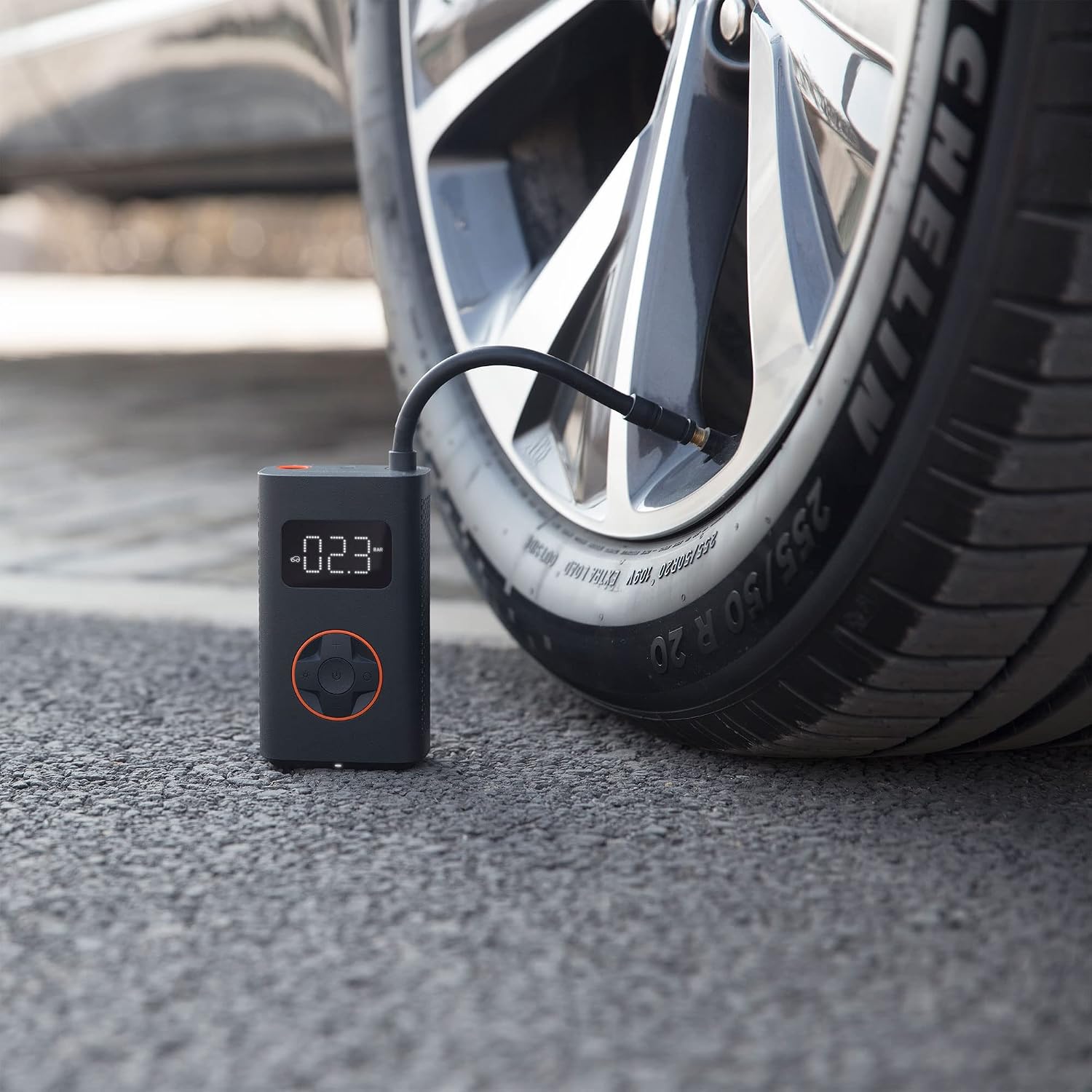 QICYCLE N2 inflating a car tire, showing digital pressure reading