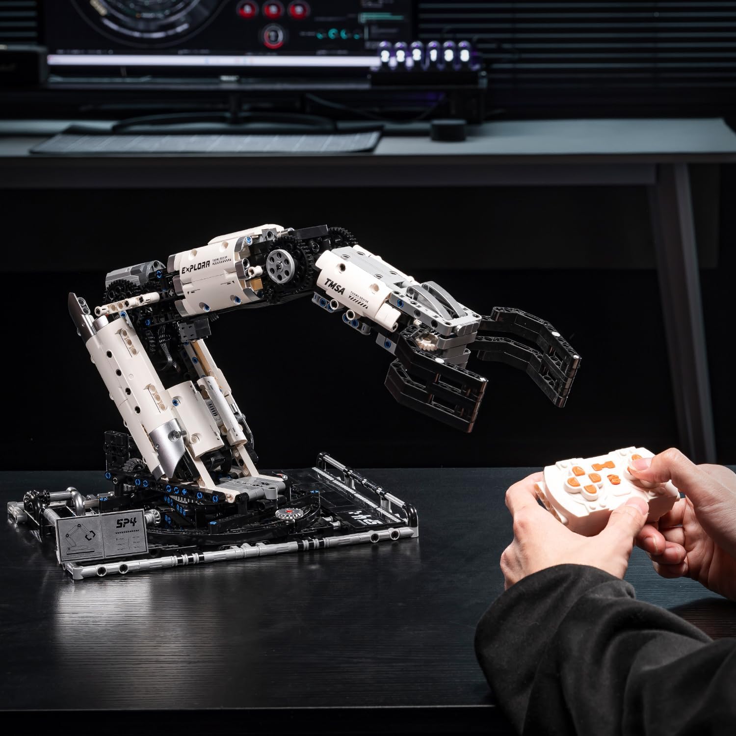 A person operating the UNCLE BRICK T2007 Mechanical Arm with the remote control.