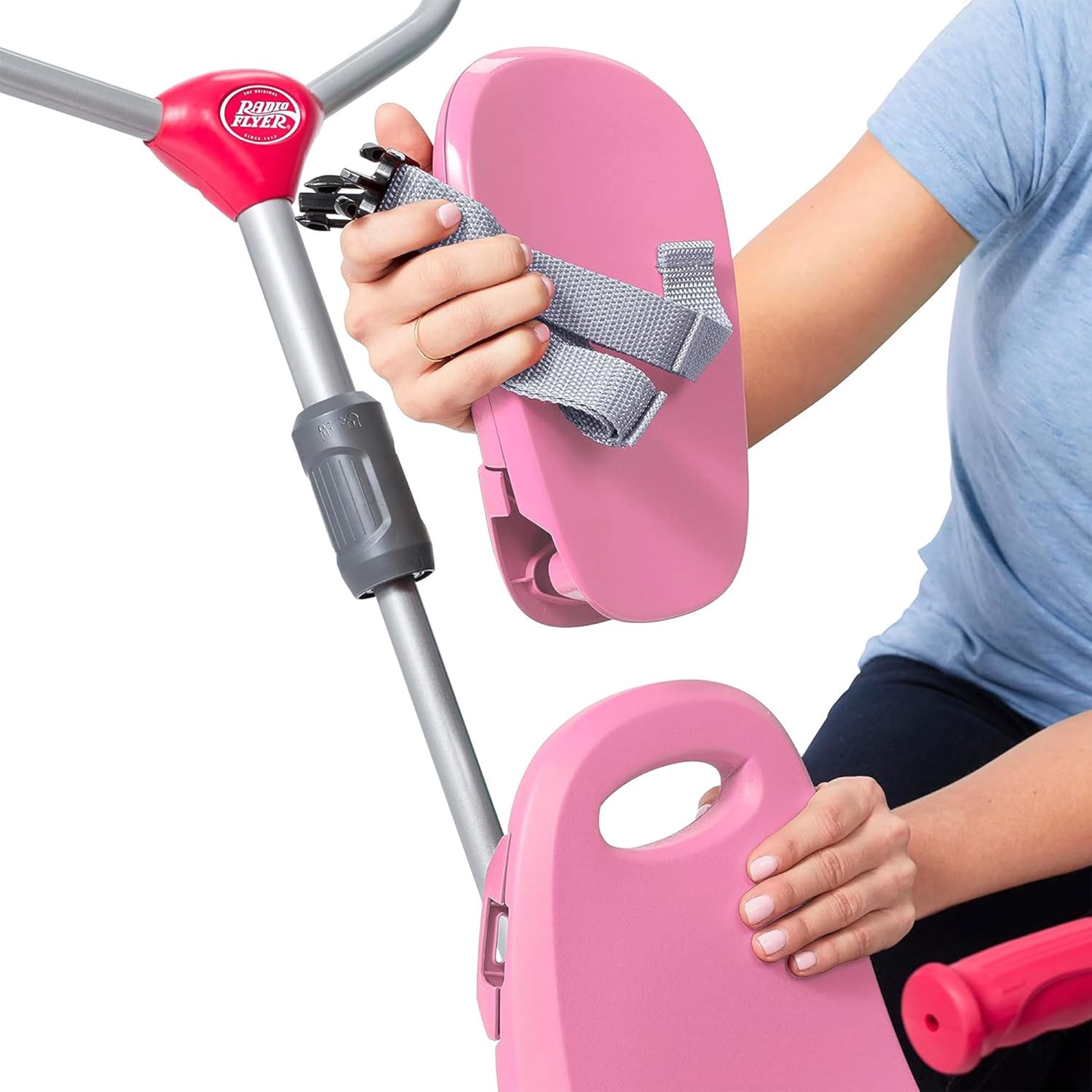 Hands removing the footrest from the trike