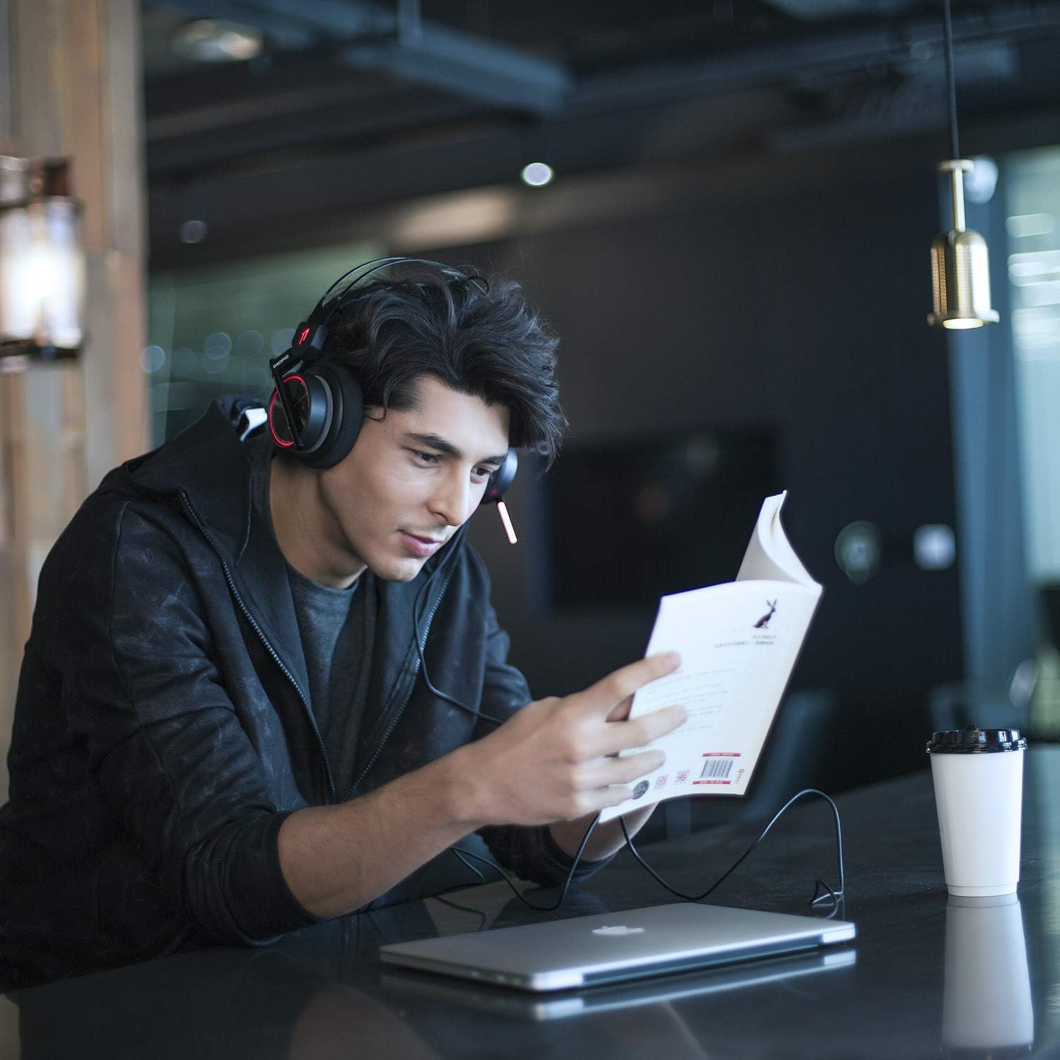 User wearing 1MORE H1005 VR Gaming Headset while reading