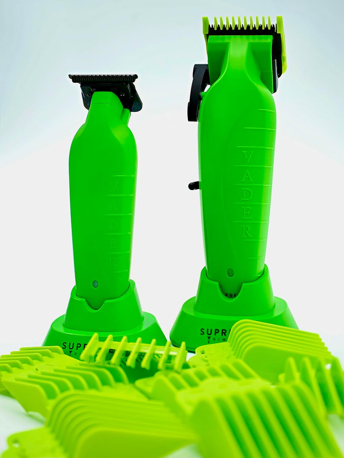 Supreme Trimmer Vader Clipper and Trimmer on their charging stands, surrounded by various green guide combs.