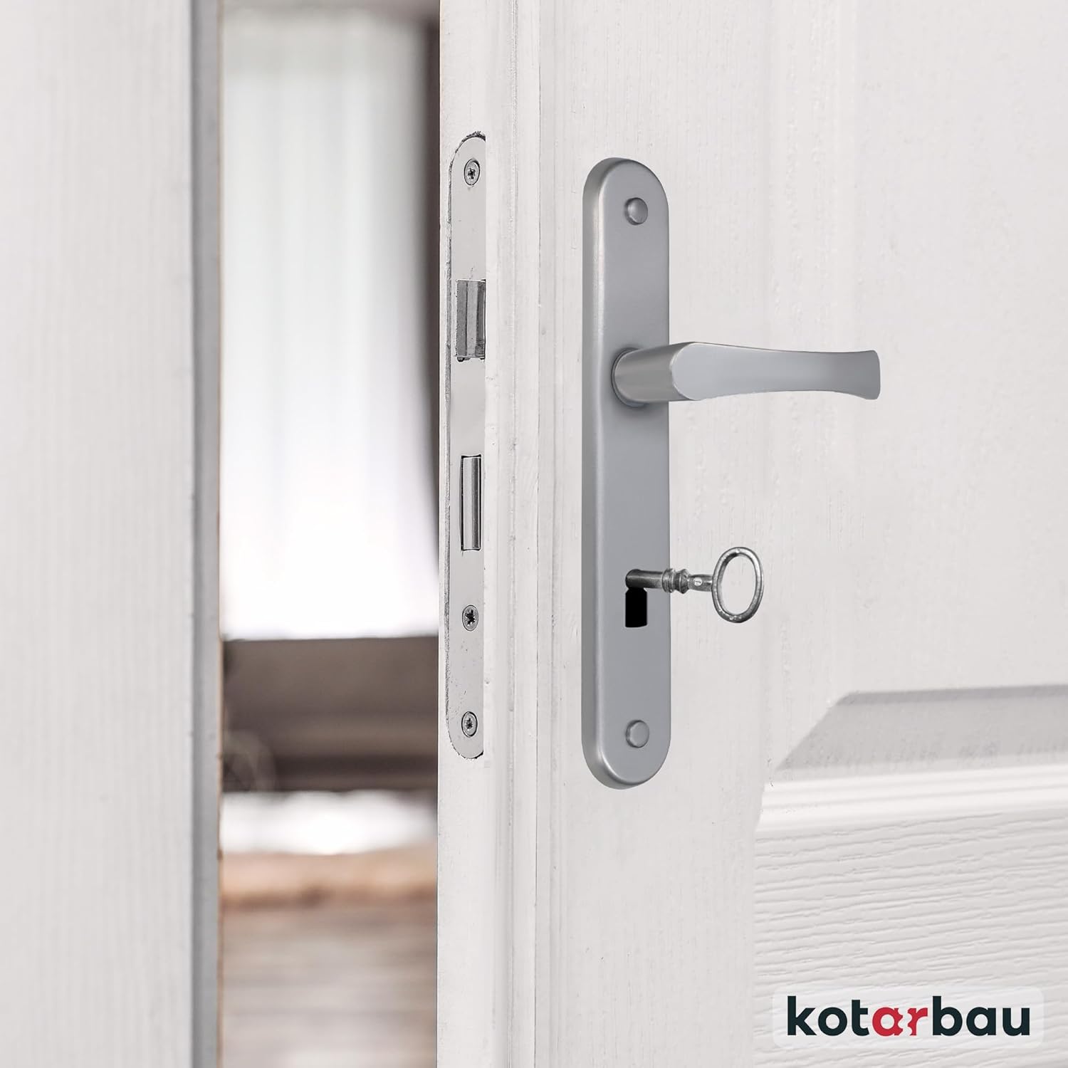 KOTARBAU Door Handle installed on a white door with a key inserted into the lock.