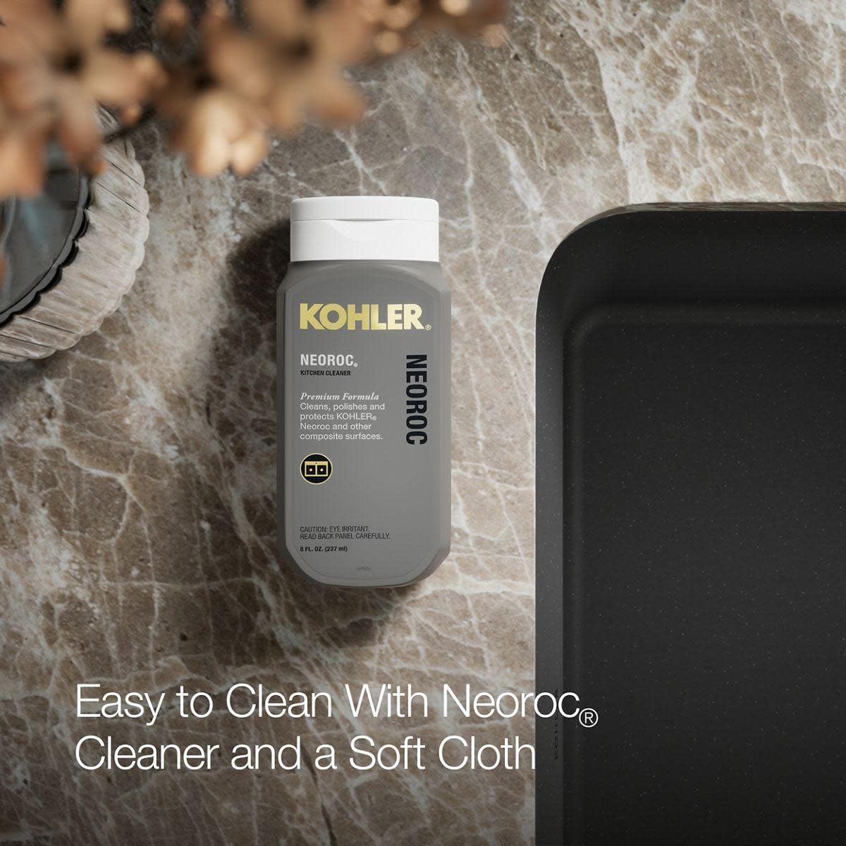 Kohler Neoroc cleaner bottle next to a dark composite sink.