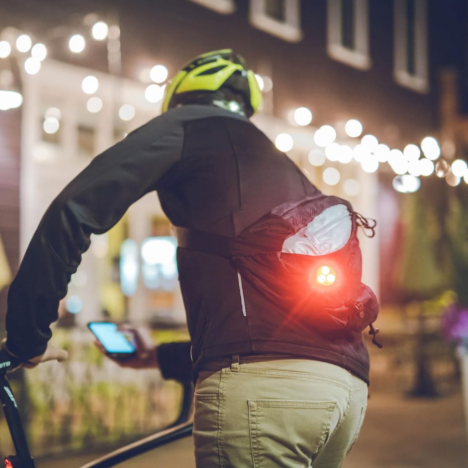 Lezyne Zecto Drive light attached to a cyclist's backpack for increased rear visibility.