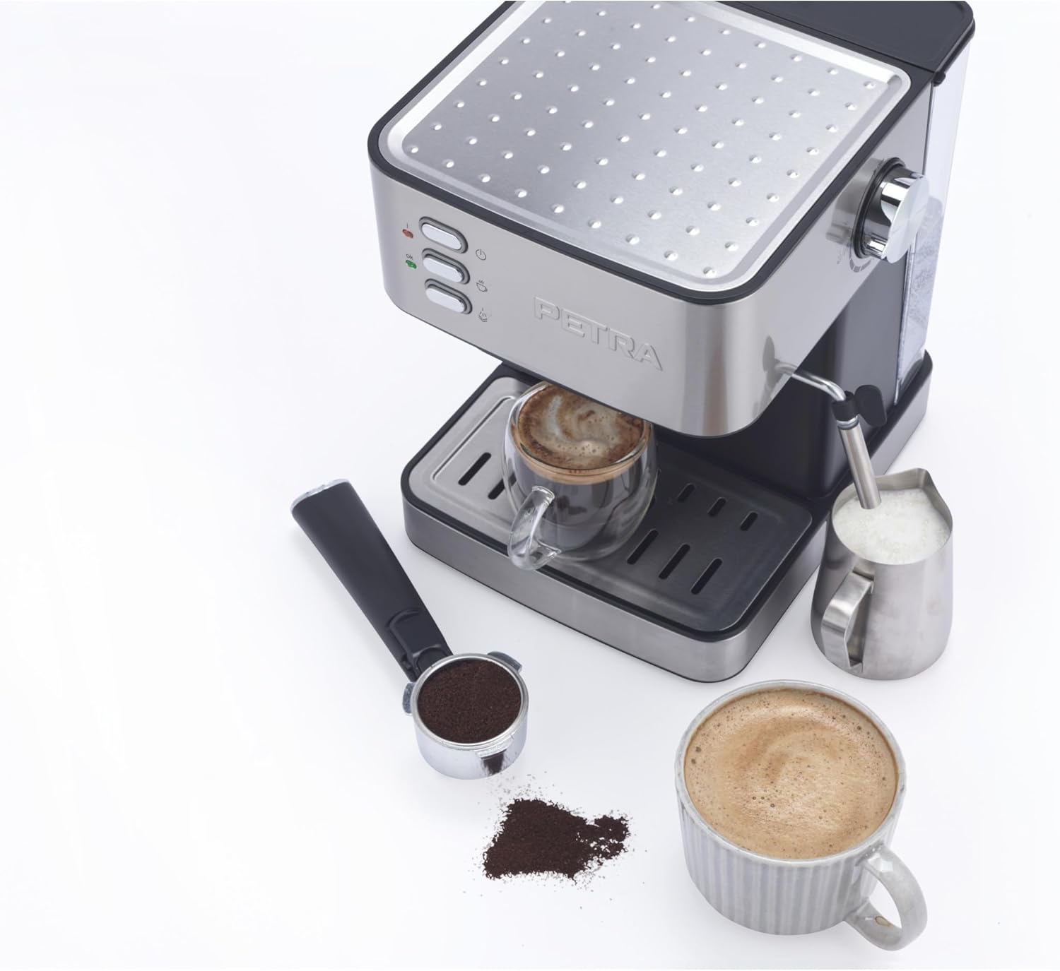 Petra espresso machine with a portafilter filled with ground coffee and a cup of frothed milk.
