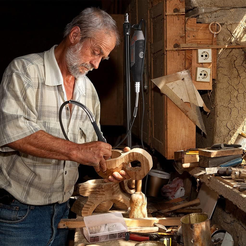 A person using the rotary tool with a flexible shaft attachment to carve details into a wooden bowl