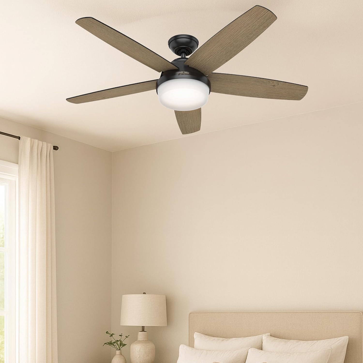 Hunter ceiling fan installed in a bedroom with light-colored walls and bedding.