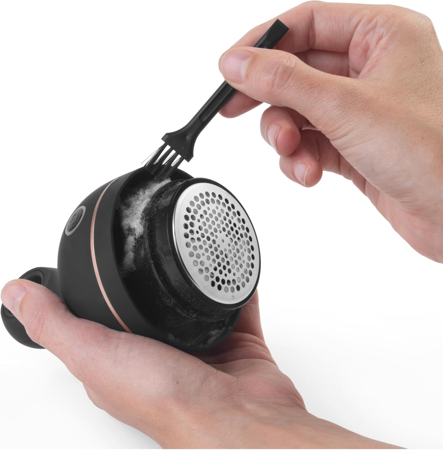 Hand using Beldray lint remover on hanging trousers