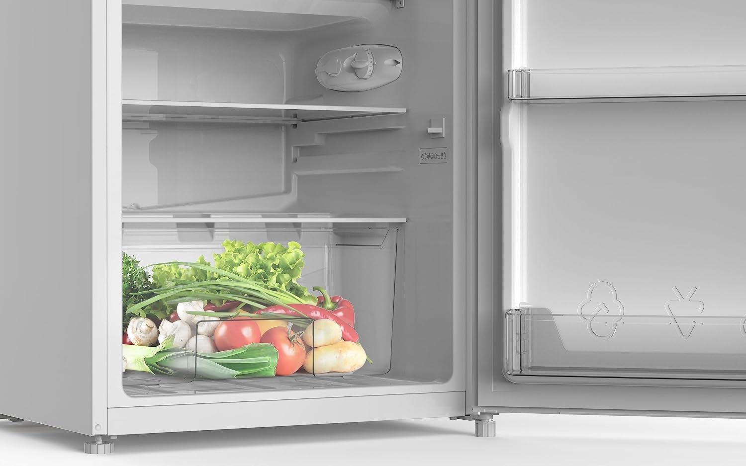 Interior of the refrigerator showing a crisper drawer filled with vegetables.
