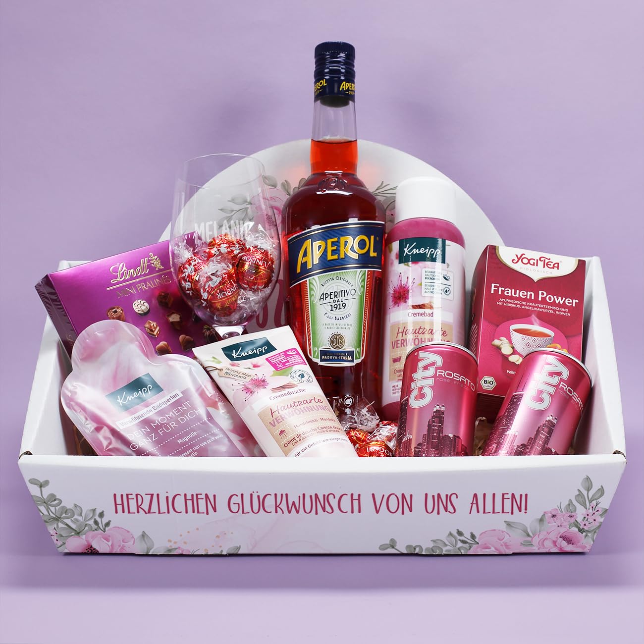 Herz & Heim® Präsentkorb für Frauen mit Süßem, 0,7l Aperol, Glas, Secco und Verwöhnprodukten (Weinglas mit Gravur) Lebensmittel & Getränke