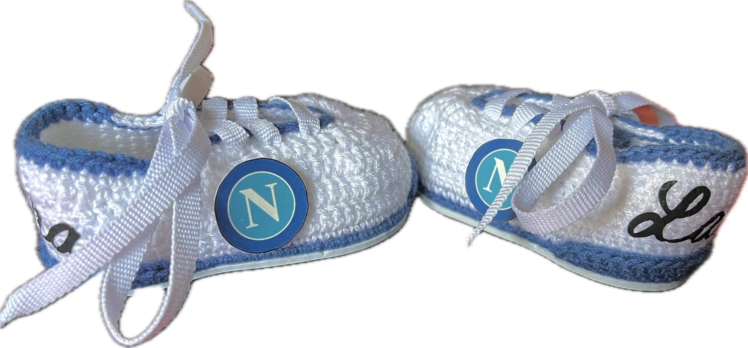 Scarpini da calcio del Napoli realizzati all'uncinetto per neonati. Personalizzato con lo stemma della tua squadra, disponibile nelle taglie da 0 a 12 mesi. Ti regaliamo il nome del bambino inciso