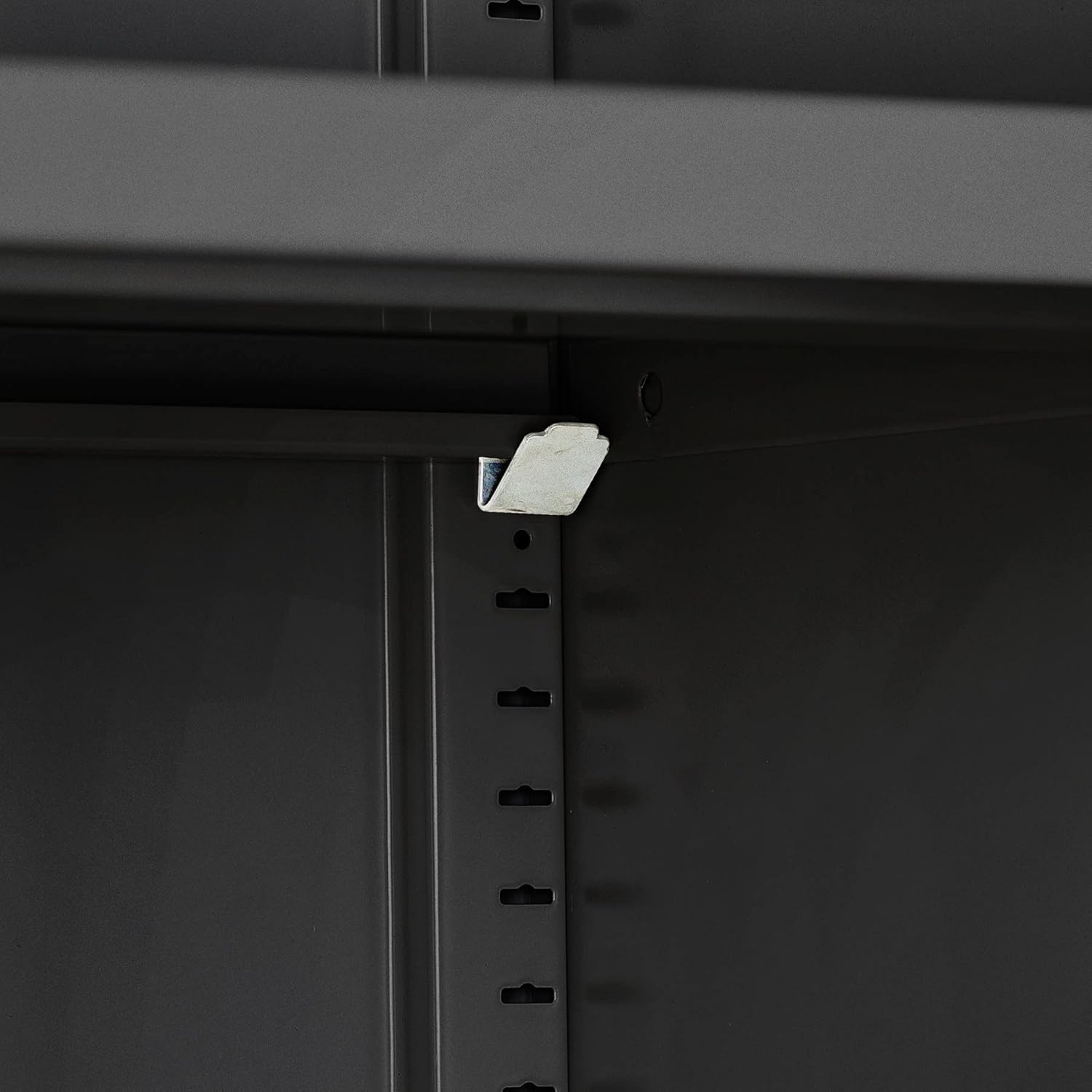 Close-up of a shelf support clip inserted into a vertical slot on the interior side panel of the cabinet.
