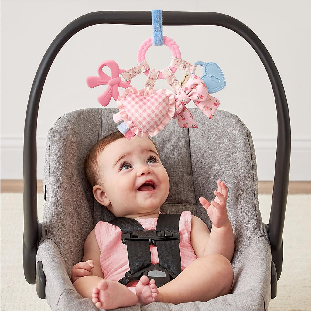 Itzy Ritzy Teething Activity Toy - Bitzy Busy Ring Infant Teething Toy Features Braided Teether & Dangling Toys, Includes Textured Ribbons, Crinkle Sound & Jingle Bell - 0 Months & Up (Pink Bow)