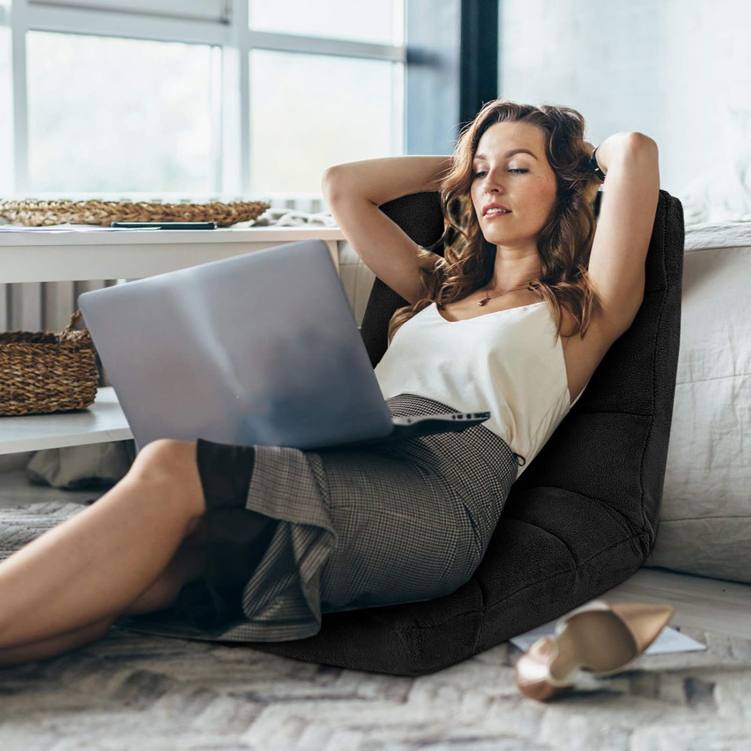 Woman relaxing on DORTALA Floor Gaming Chair with a laptop
