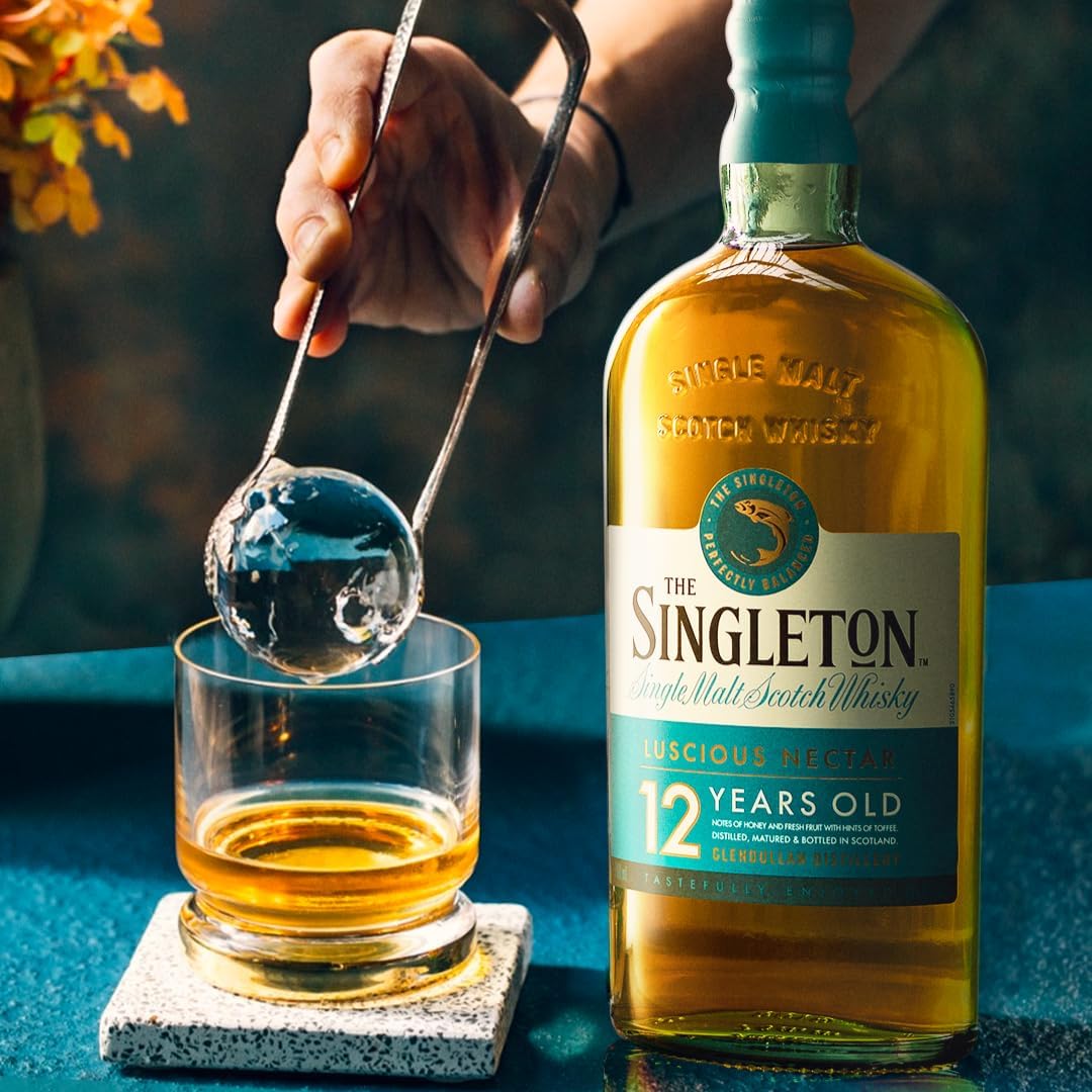 Imagem lateral da garrafa com fundo desfocado em tons escuros. Imagem lateral da garrafa com fundo desfocado em tons escuros.