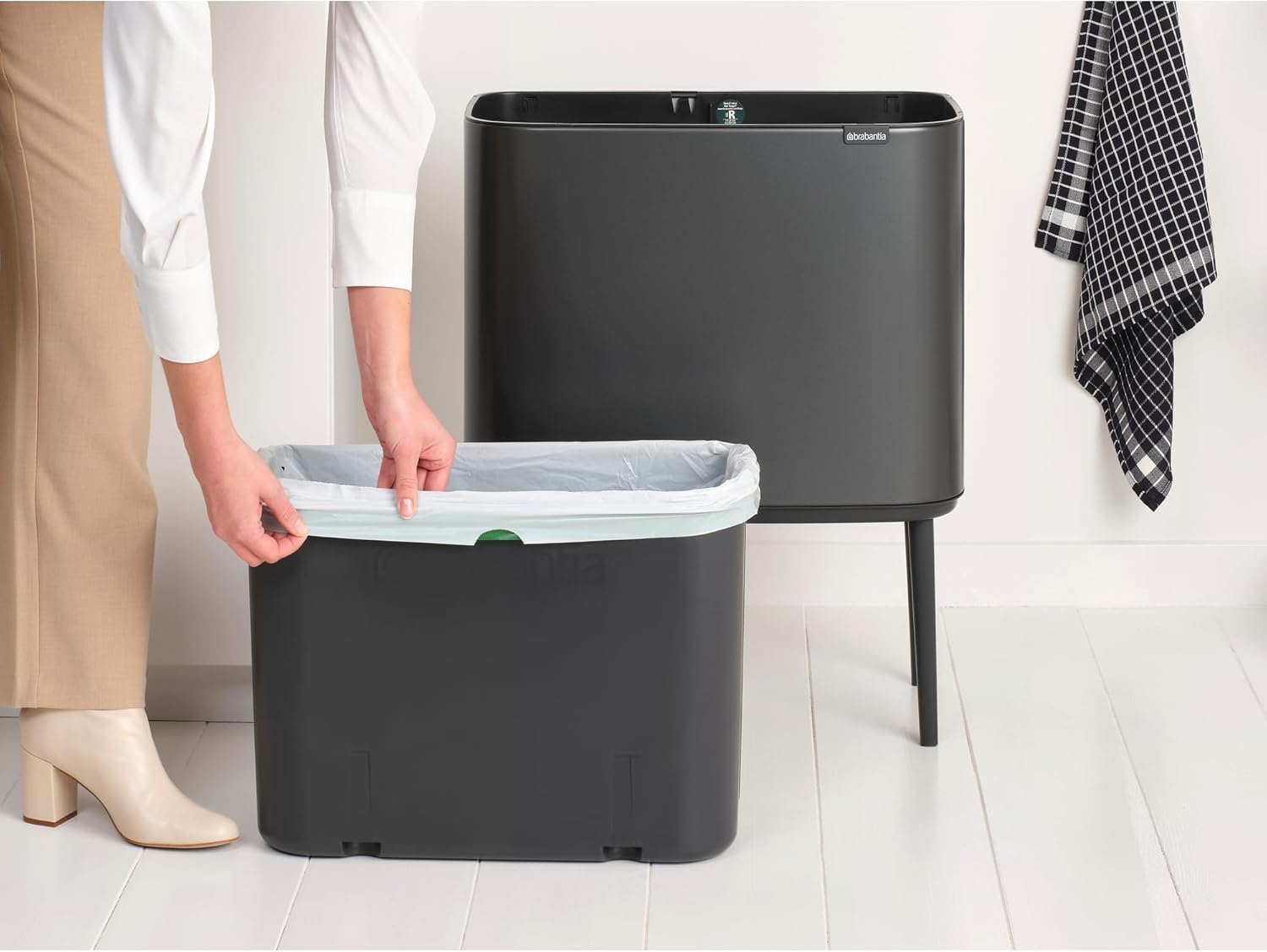 Person inserting a trash bag into the inner bucket of the Brabantia Bo Touch Top Trash Can