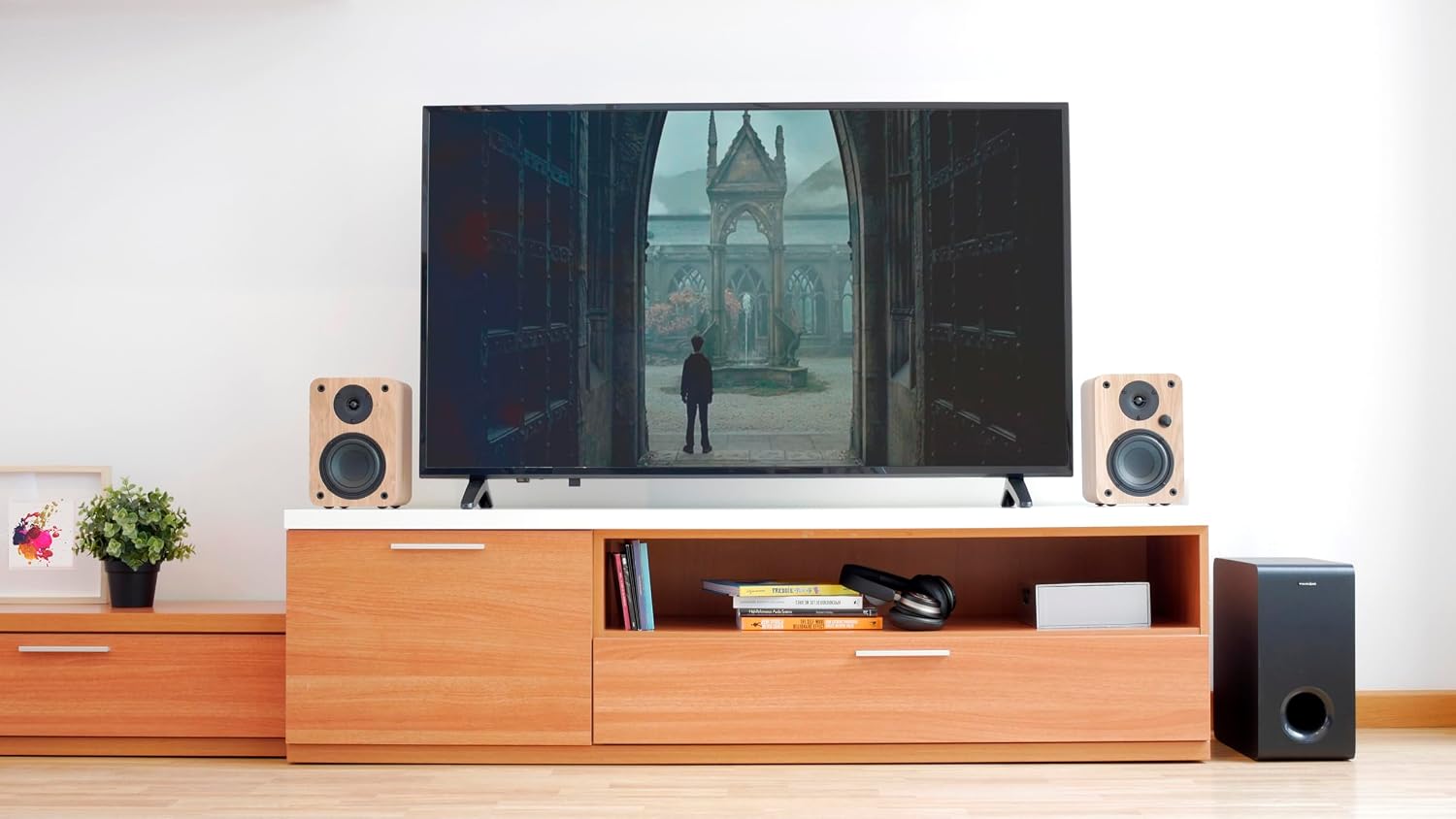 VULKKANO SUB6 subwoofer placed next to a TV stand with speakers