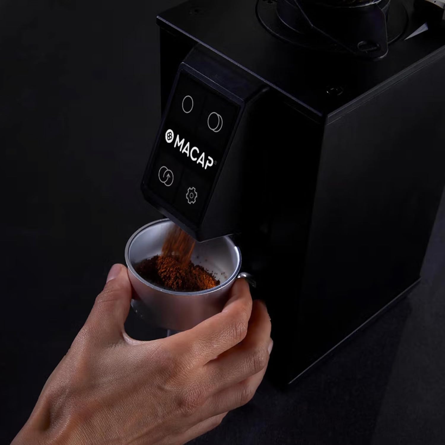 Ground coffee being dispensed from the MACAP LEO 55 Touch grinder into a portafilter, demonstrating the hands-free auto grinding feature.