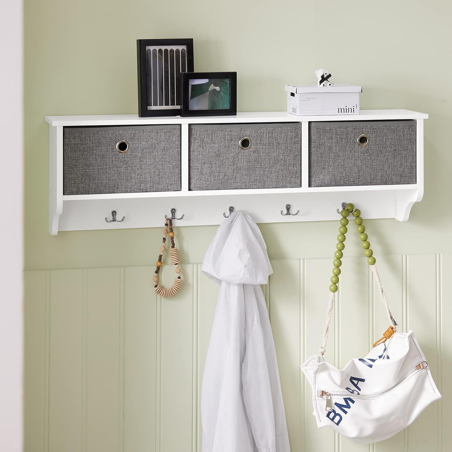 SoBuy wall-mounted coat rack in an entryway, holding a white jacket, a beaded necklace, and a white canvas bag.