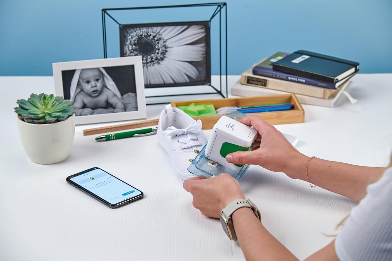 Colop e-Mark Go printer being used with a guide to print a design onto a white canvas shoe.