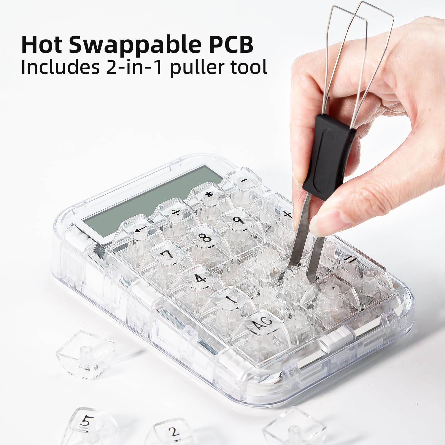 Hand using a 2-in-1 puller tool to remove a switch from the numeric keypad.