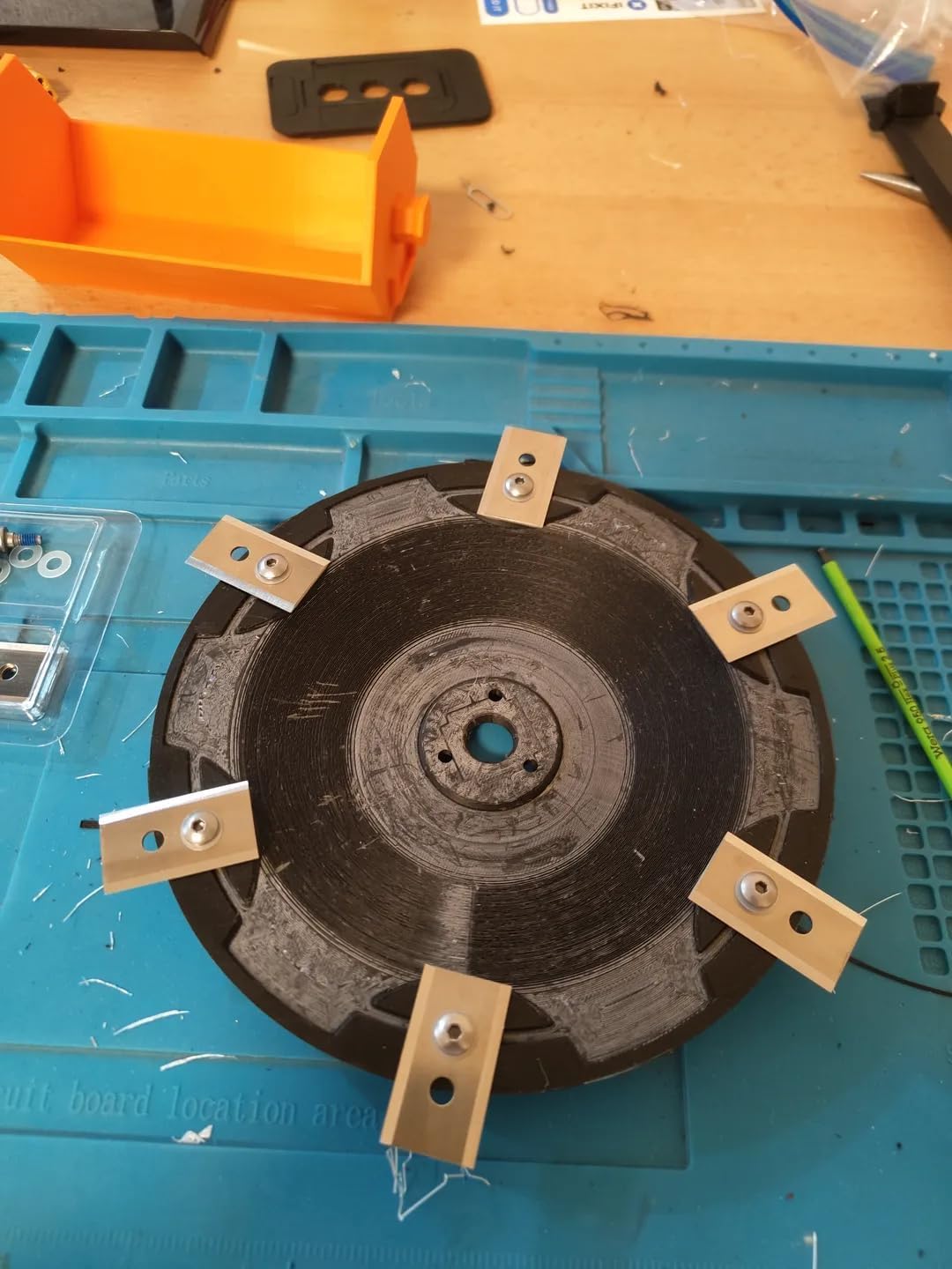 Close-up of a single black replacement cutting disc with blades attached.