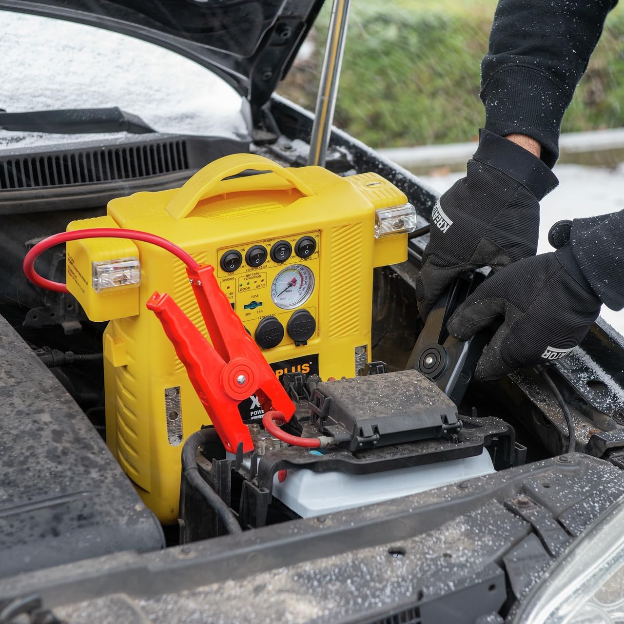 Close-up of jumper cables connected to a car battery terminals