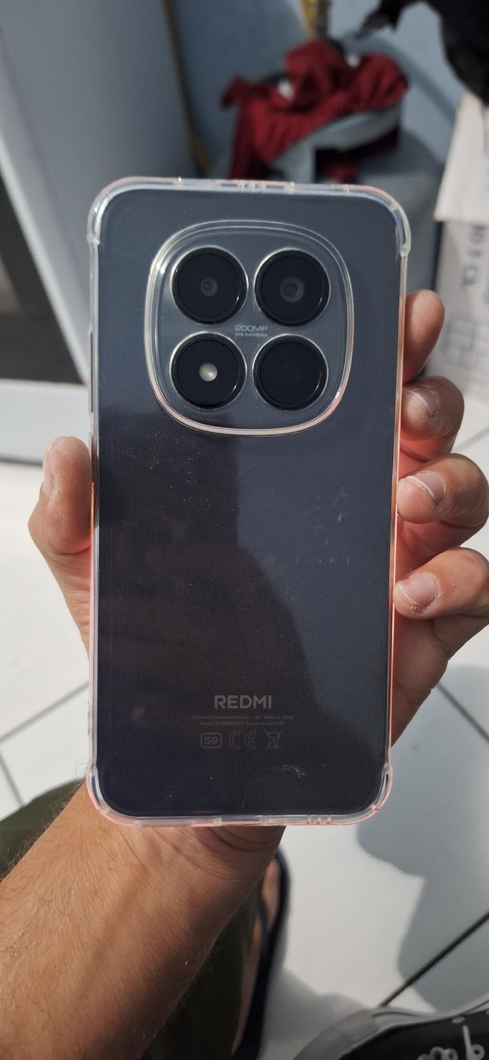 Smartphone com uma capa transparente mostrando a câmera quádrupla e o logotipo Redmi.