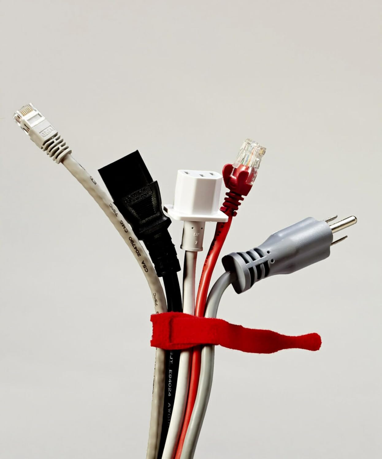 Multiple electronic cables bundled together with a red Scotch Bundling Strap.