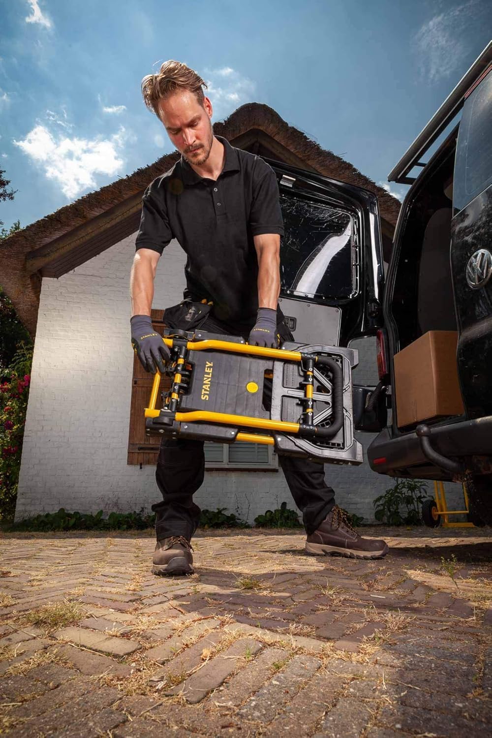Man folding the Stanley hand truck for storage