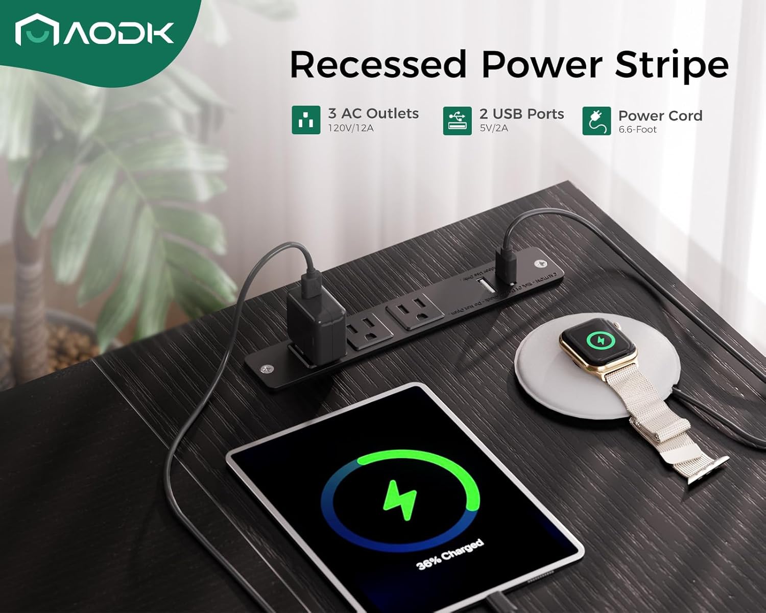 Close-up of the recessed power strip on the AODK L-shaped desk, showing 3 AC outlets and 2 USB ports with devices charging.