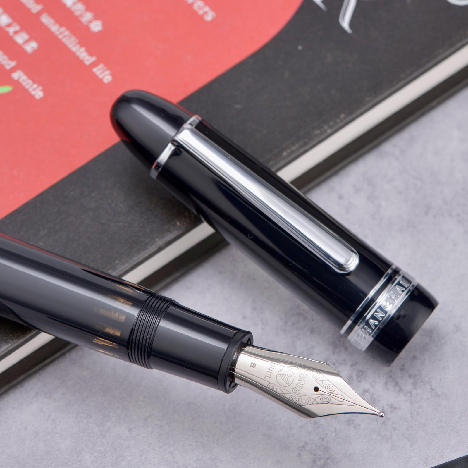 Yongsheng Junlai 930 - Pluma estilográfica acrílica, plumín mediano tamaño 9 con sistema de llenado de pistón, tanque de tinta de valla negro piano con diseño de forma de torpedo (Borde Plateado)