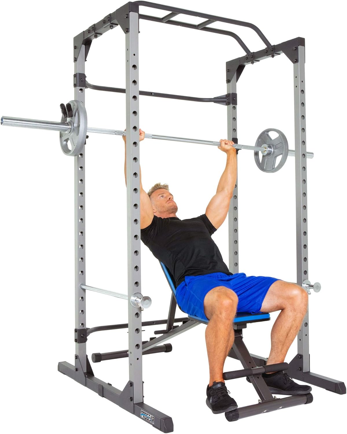 Person performing a bench press inside the power cage with a weight bench