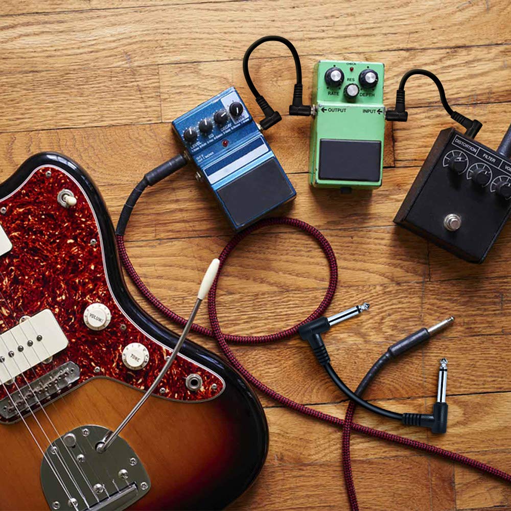 Multiple guitar pedals connected with LEKATO patch cables alongside a guitar