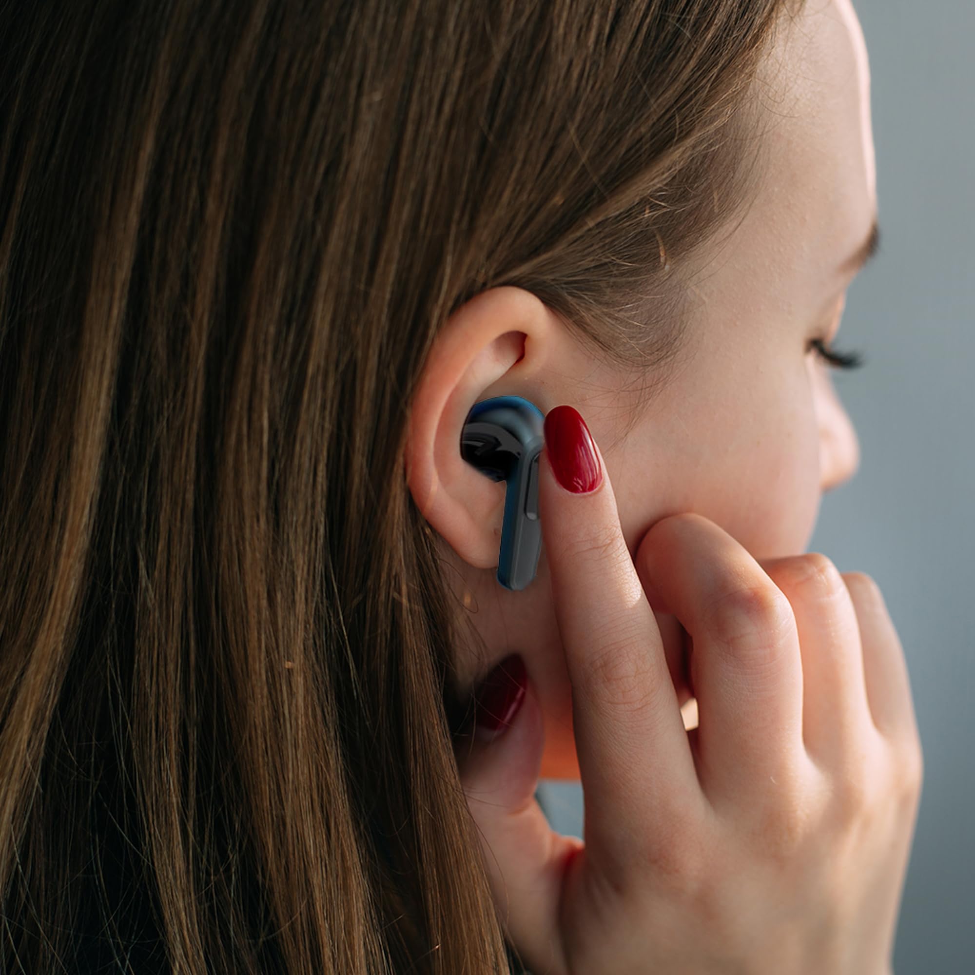Woman smiling while wearing a Laser TWS Earbud and looking at her phone