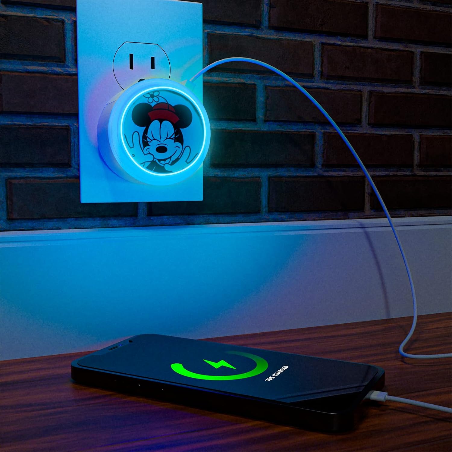 Minnie Mouse night light plugged into a wall outlet, charging a smartphone with a blue light glow.