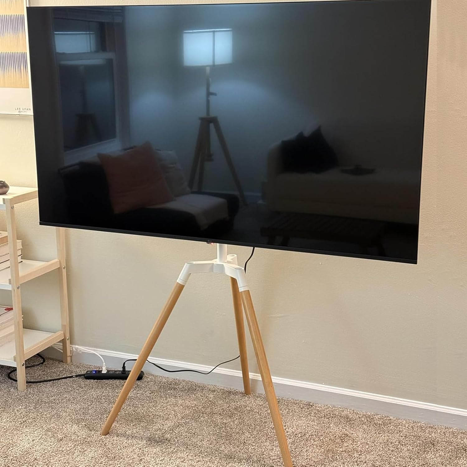 Assembled Fydeamer TV stand in a living room with a TV displaying a dark screen.