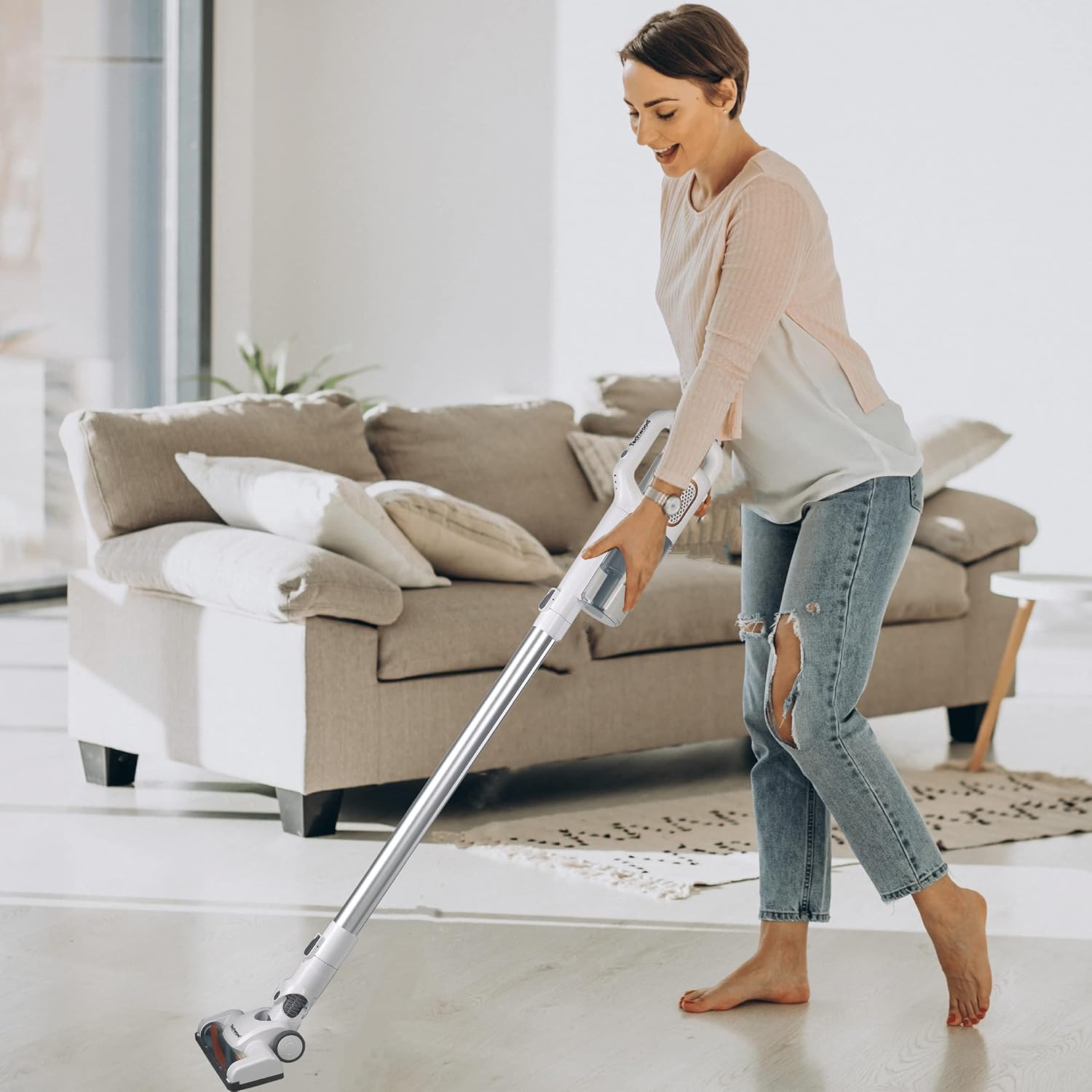 Person using Techwood TAB-311 Cordless Stick Vacuum Cleaner on a hard floor