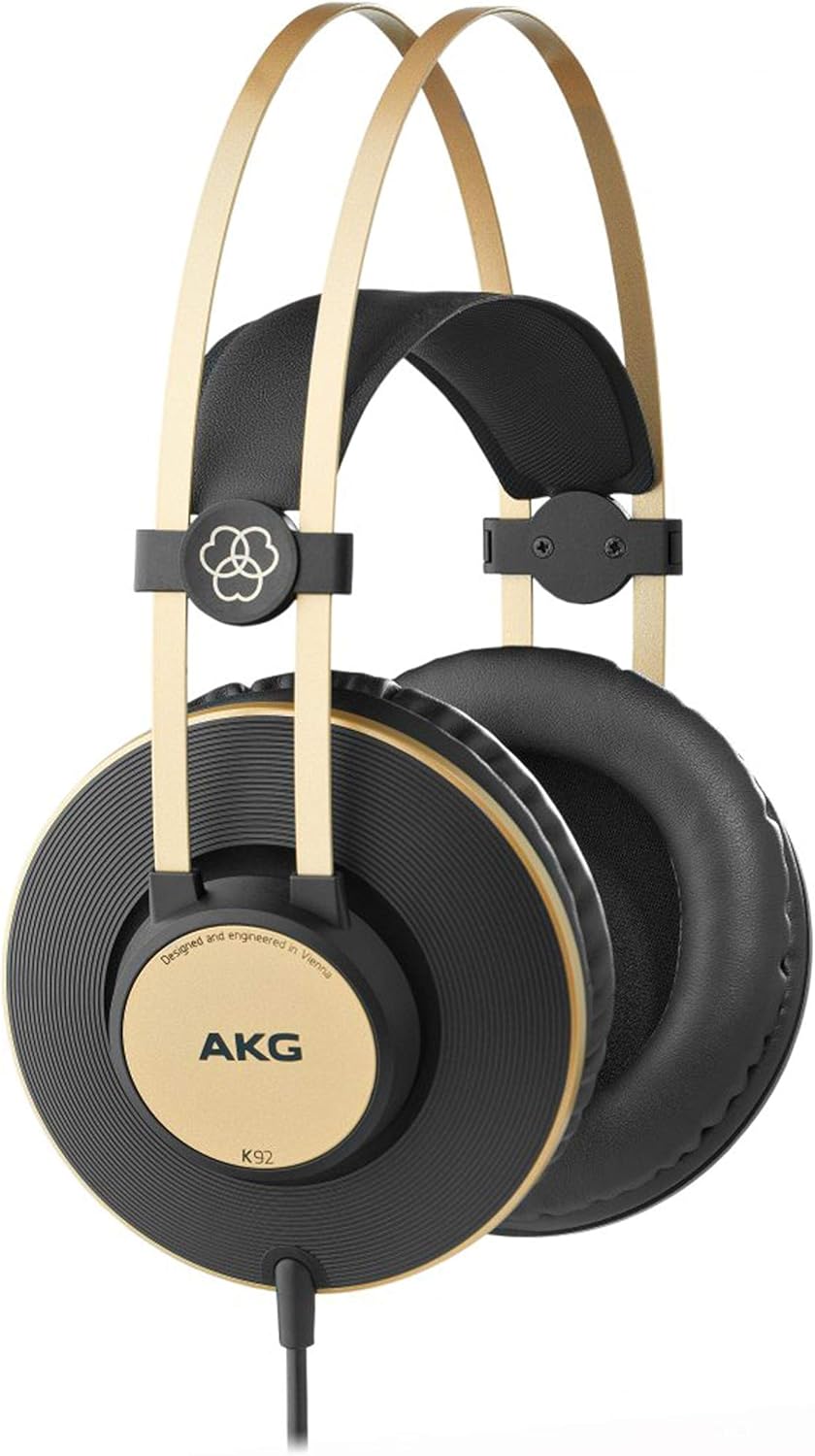 Fone de ouvido AKG K92 com design over-ear, almofadas pretas e detalhes dourados, arco duplo dourado flexível, logo AKG e cabo preto, fundo branco.
