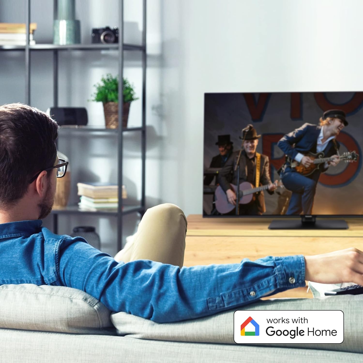 Man watching Panasonic TV with 'Works with Google Home' logo