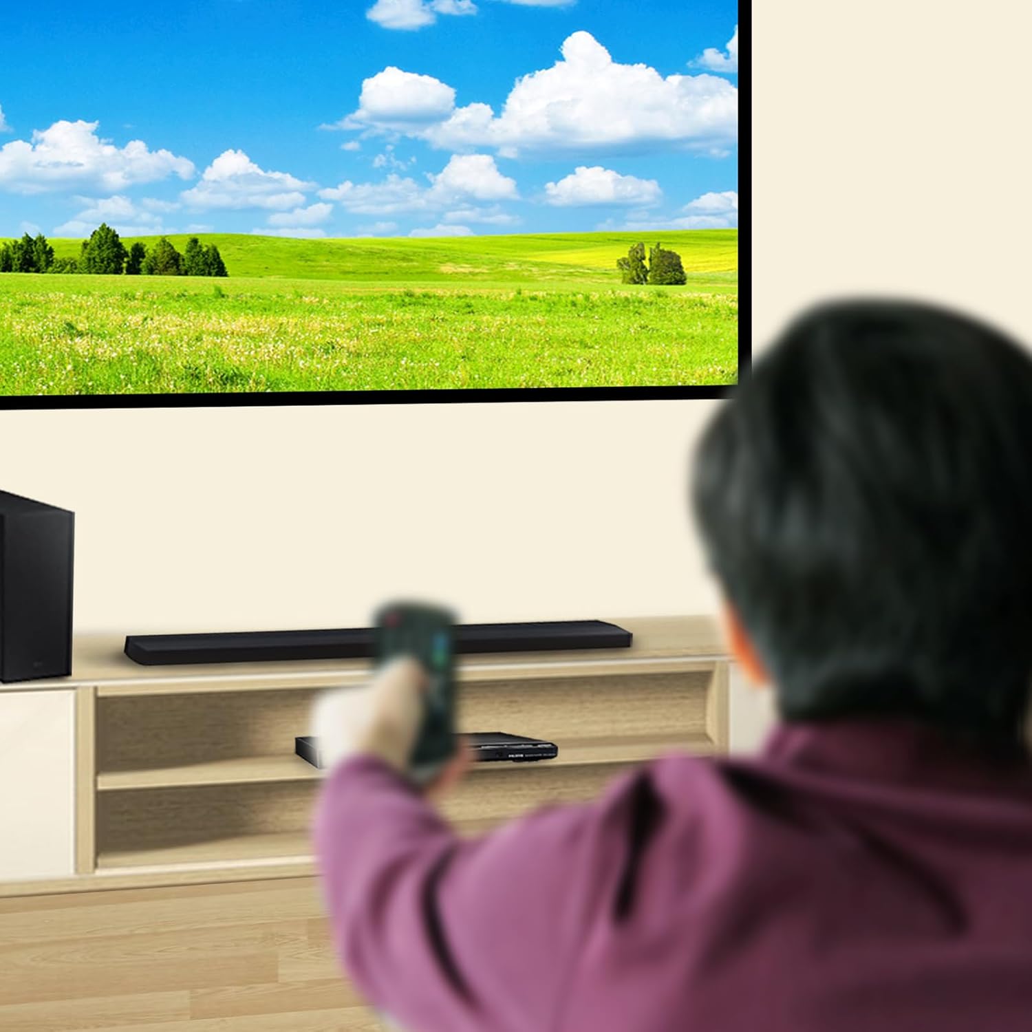 A person using the remote control to operate a set top box connected to a television.