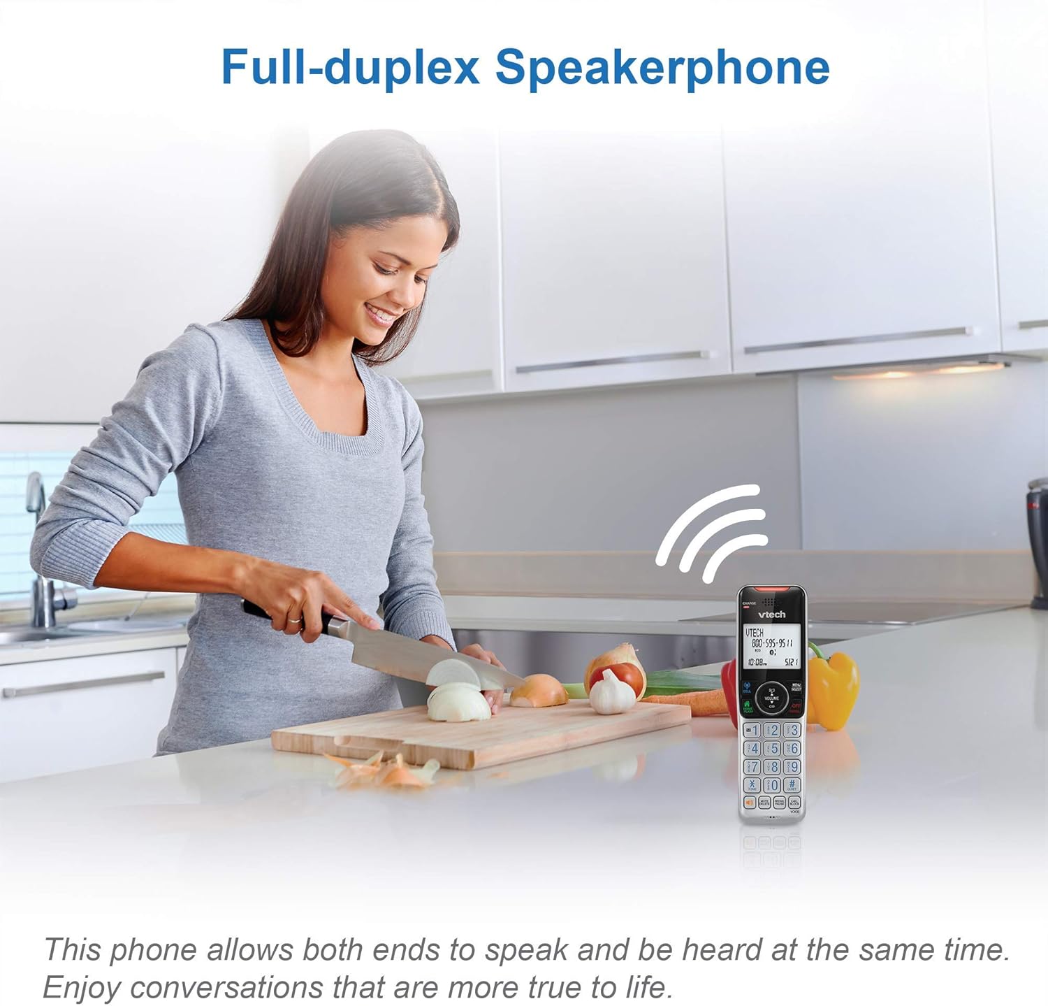 A woman using the VTECH cordless phone's speakerphone feature while preparing food in a kitchen.