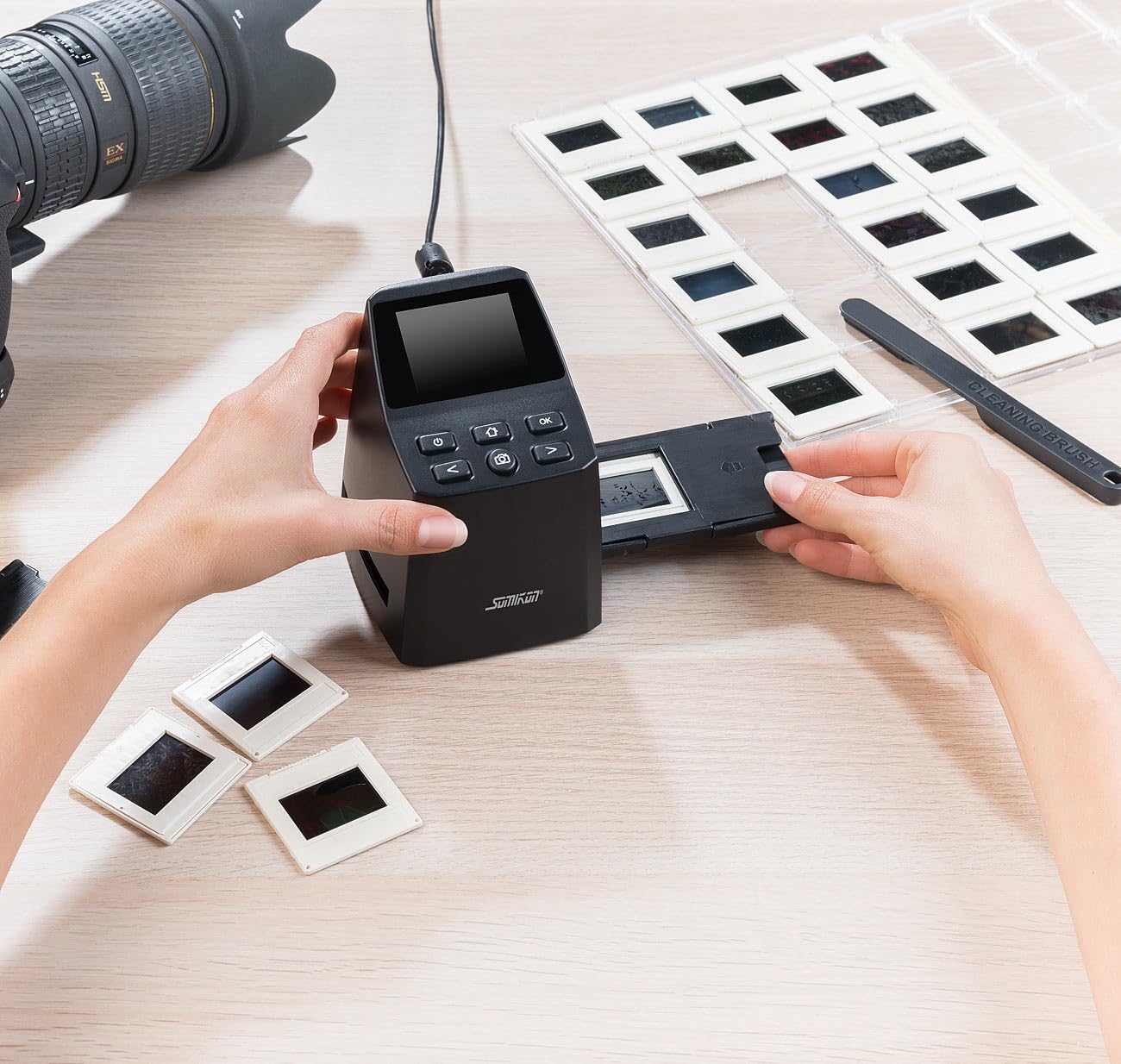 A hand inserting a loaded slide holder into the side slot of the Somikon SD-950 scanner.