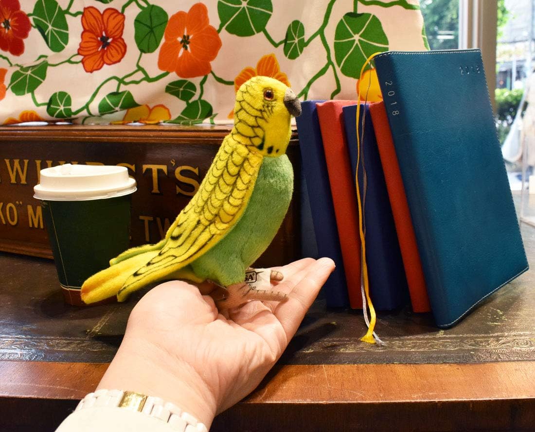 Hansa Plush Budgerigar held in a hand for size comparison