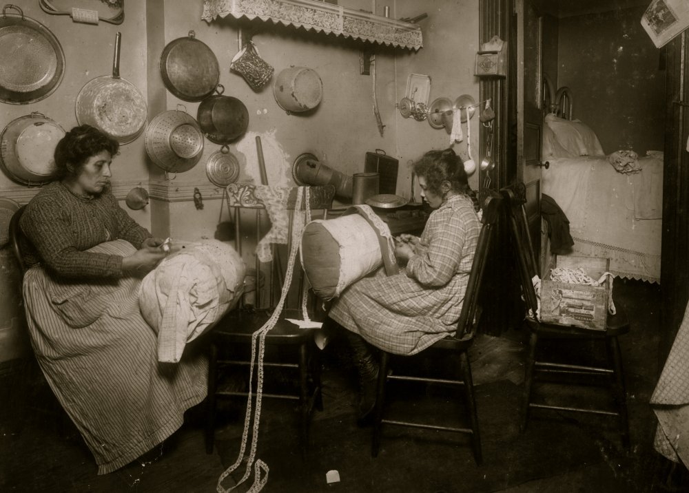 Mrs Palontona and 13 year old daughter Michaeline working on Pillow-lace in dirty kitchen of their tenement home 213 E 111th Street 3rd floor They were both very illiterate Mother is making fancy lace