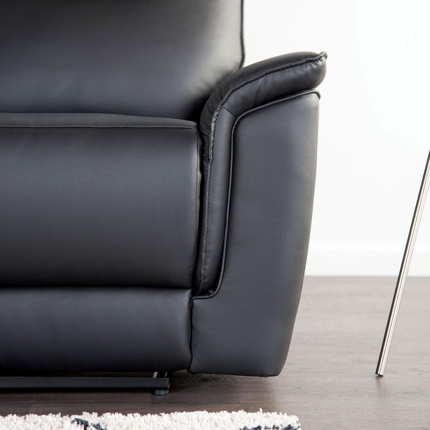 Lato view of a black leather recliner chair in a partially reclined position